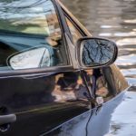 man pulling out his car out of the flood