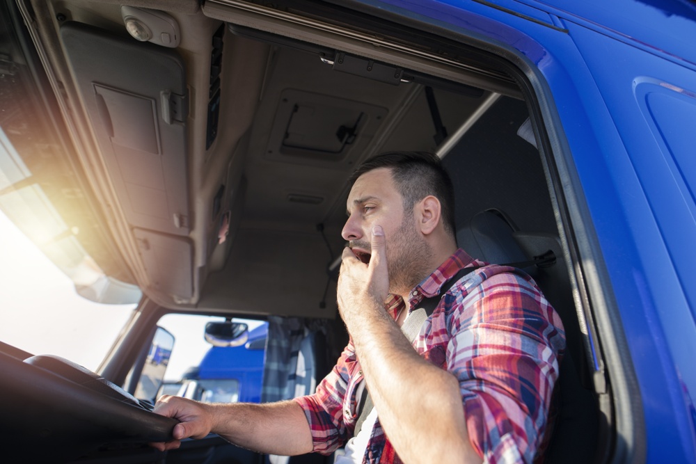 drowsy truck driver yawning while driving