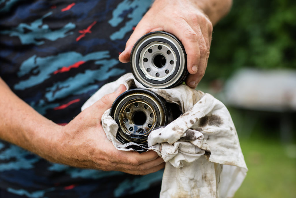 Comparing new oil filter with old filter while performing oil filter replacement