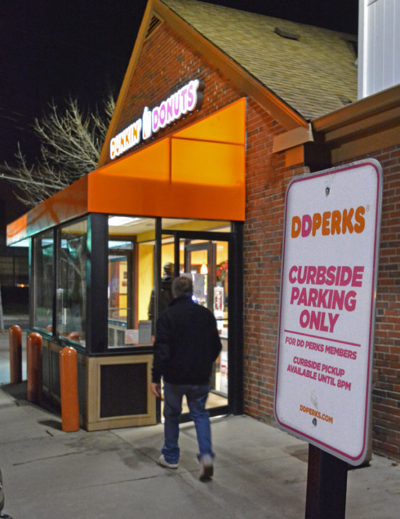 A Dunkin Donuts curbside parking sign