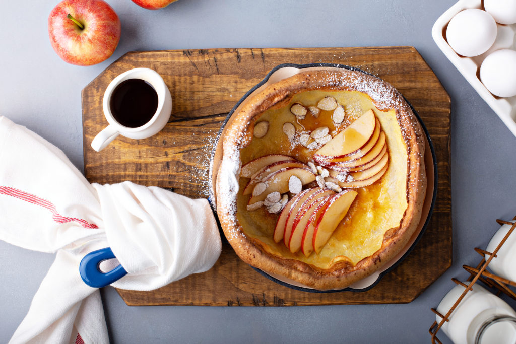 Dutch baby pancake with apples, powdered sugar, and almonds