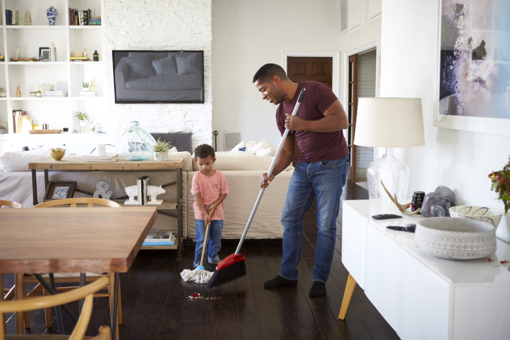 Father and son mopping and sweeping, cleaning the house for Mom