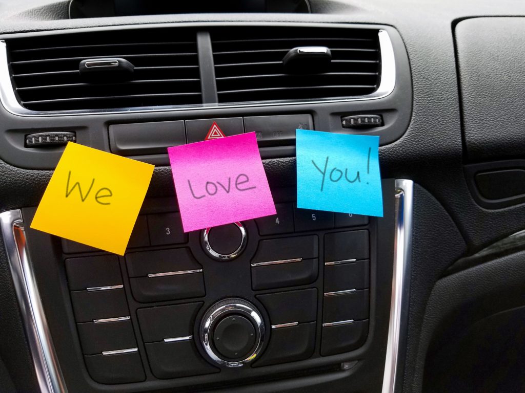 Post-its saying "We Love You!" in clean car interior