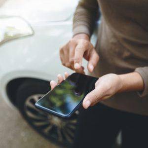 man using iphone on the road