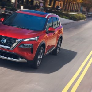 red nissan rogue on the road