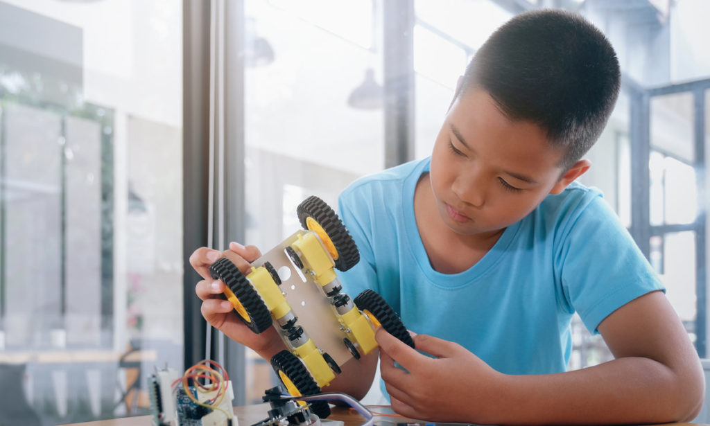 young boy building toy car