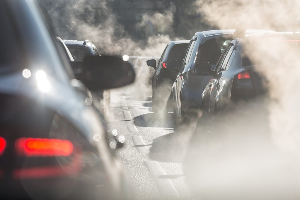 cars on highway surrounded by steam from exhaust