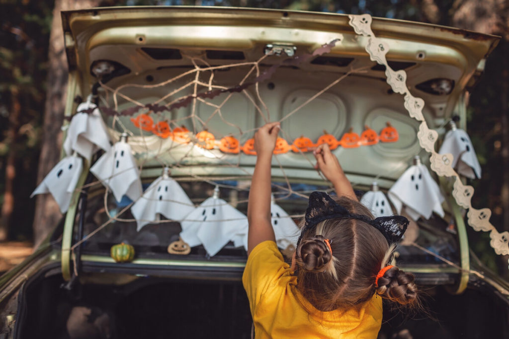 kid decorating car for halloween