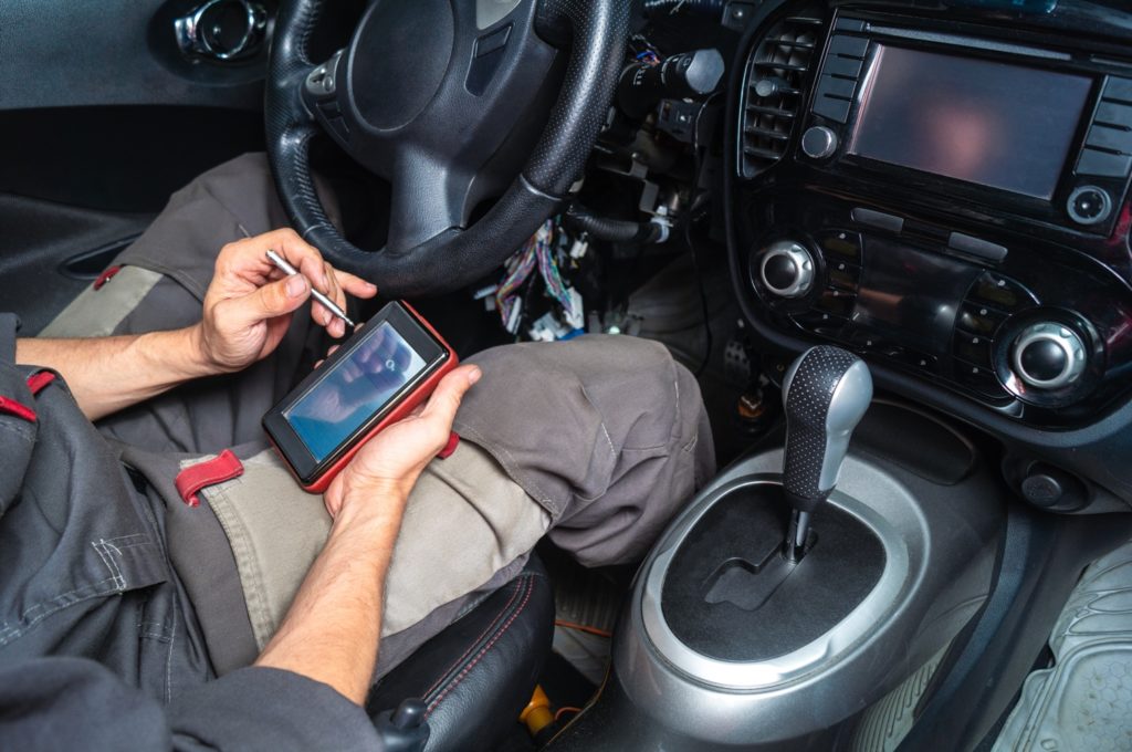 mechanic reading trouble code using portable auto scanner