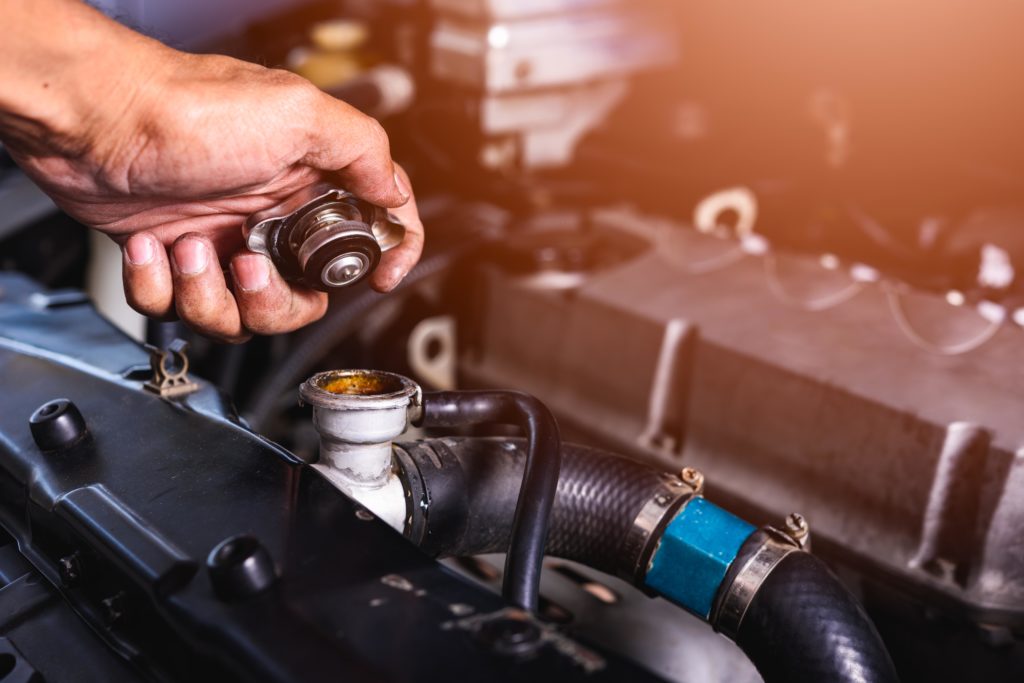 mechanic holding a radiator cap