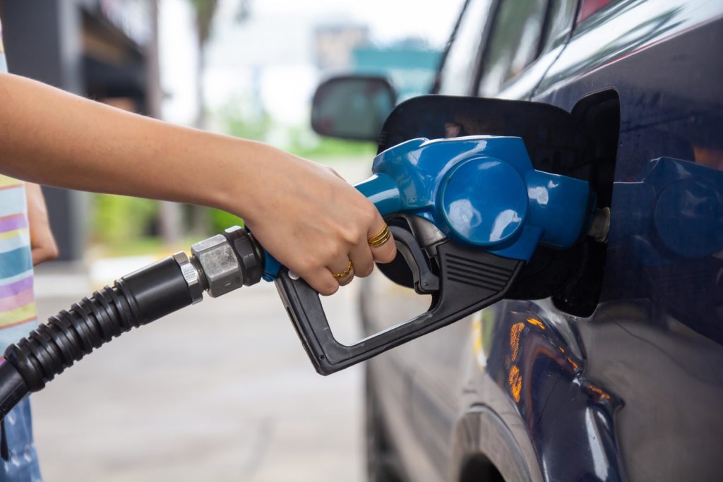 Blue car at gas station getting refuelled