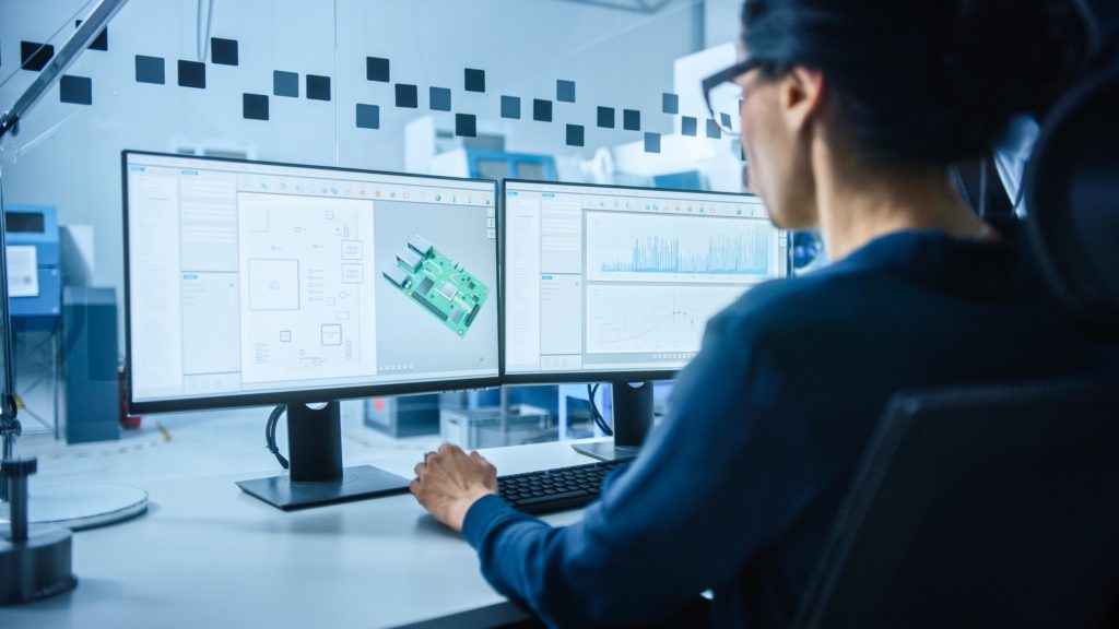 Female Electrical Engineer Works on Computer with CAD Software