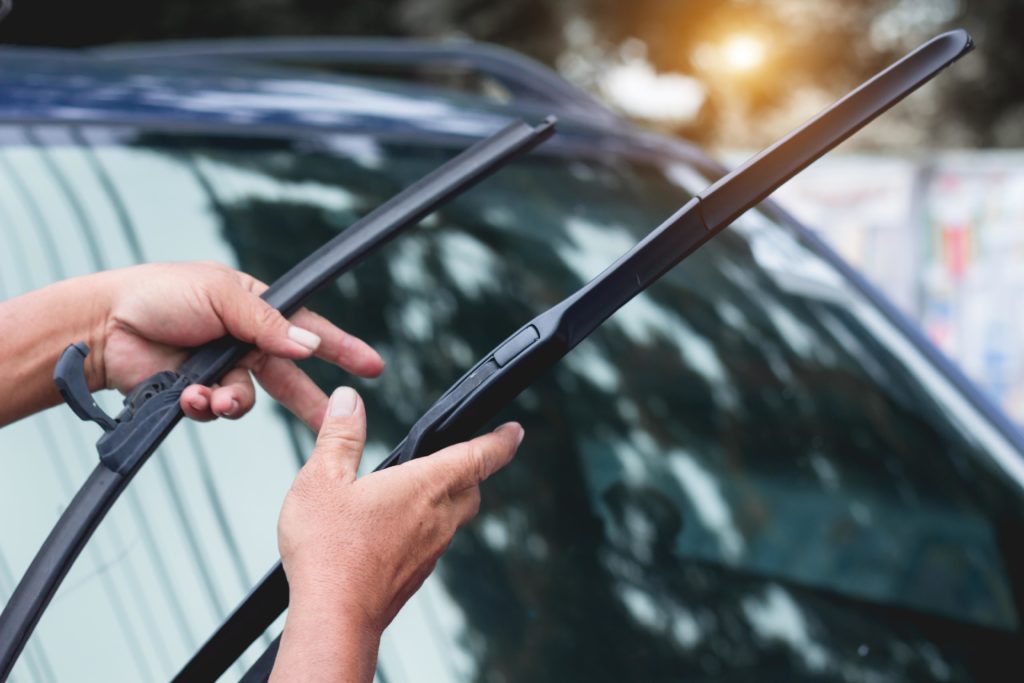 man holding two wiper blades