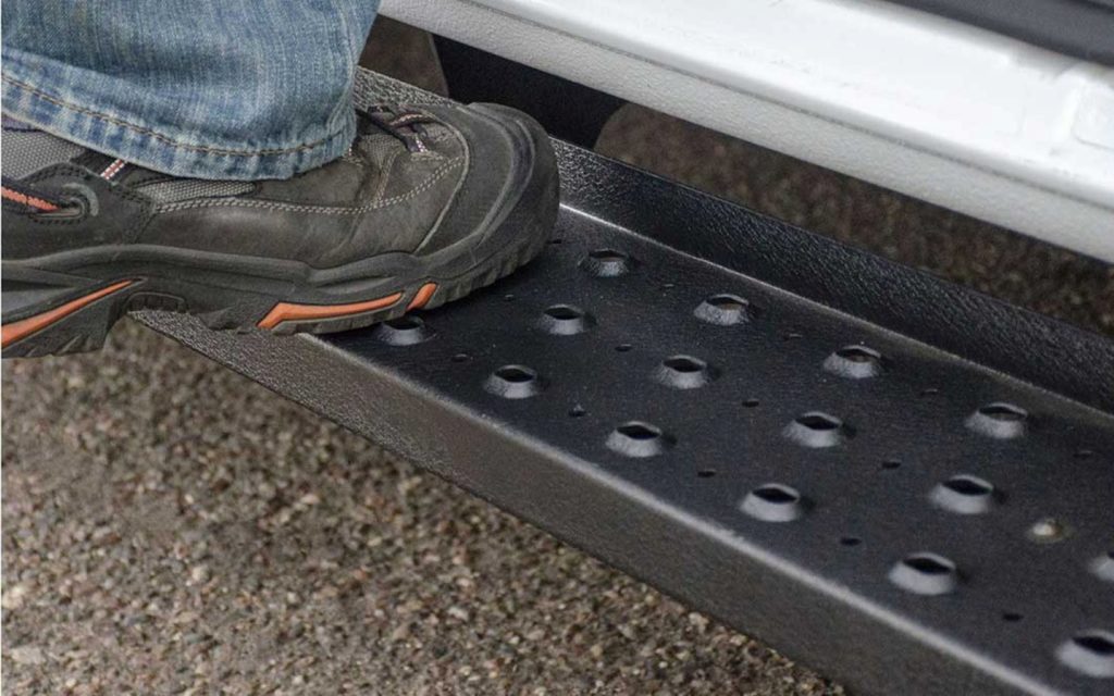 driver stepping on a running board of a truck