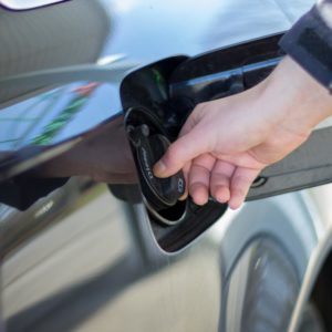 driver holding the gas cap of a car for checking