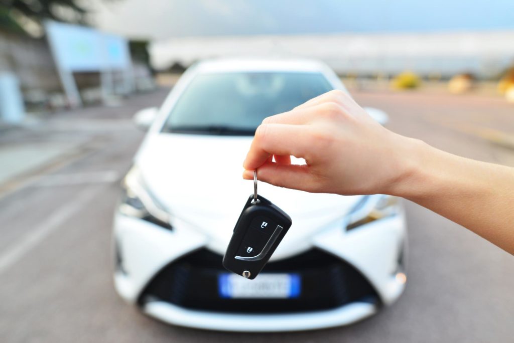 hand holding a car key for white car