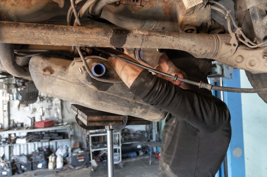 mechanic replacing car fuel tank