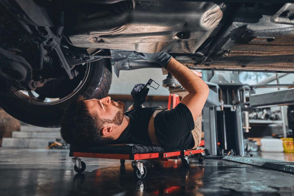 mechanic performs installation under car