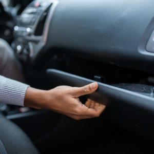 hand opens car glove compartment