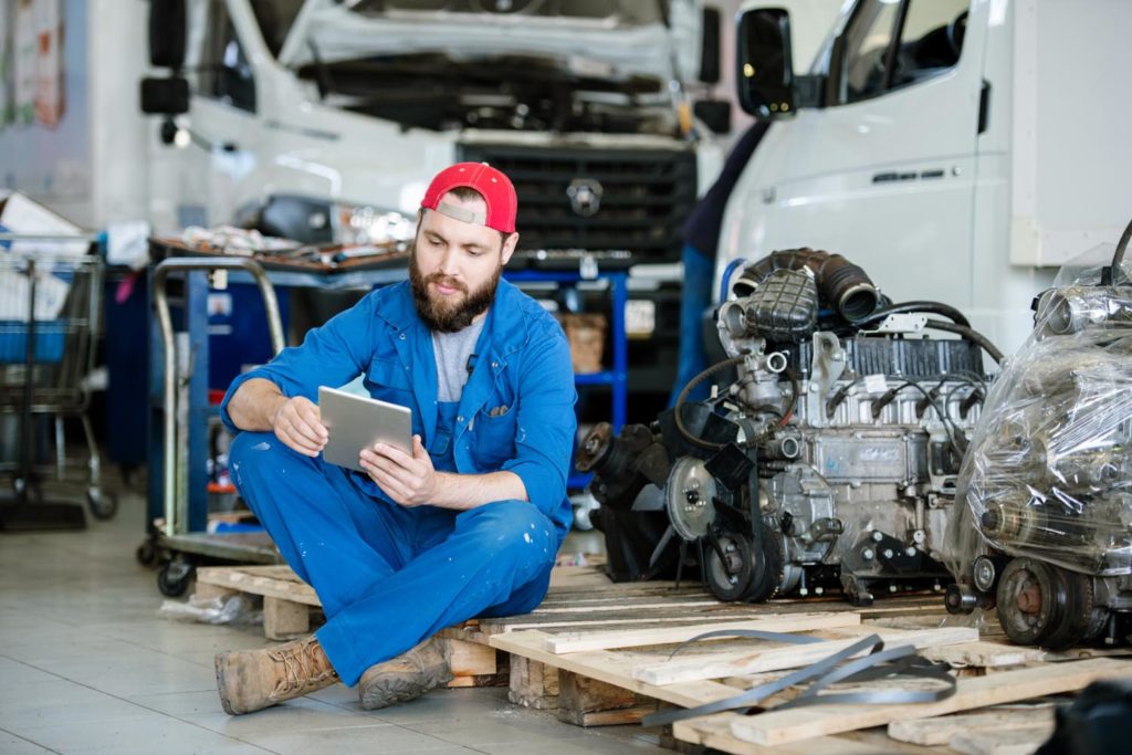 mechanic checking manual using tablet