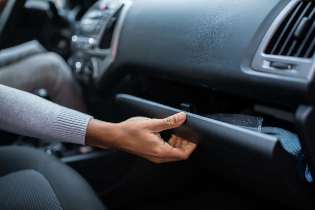 person opens car glove compartment