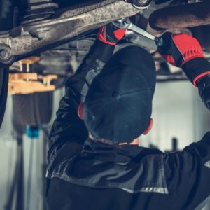 mechanic checking car undercarriage