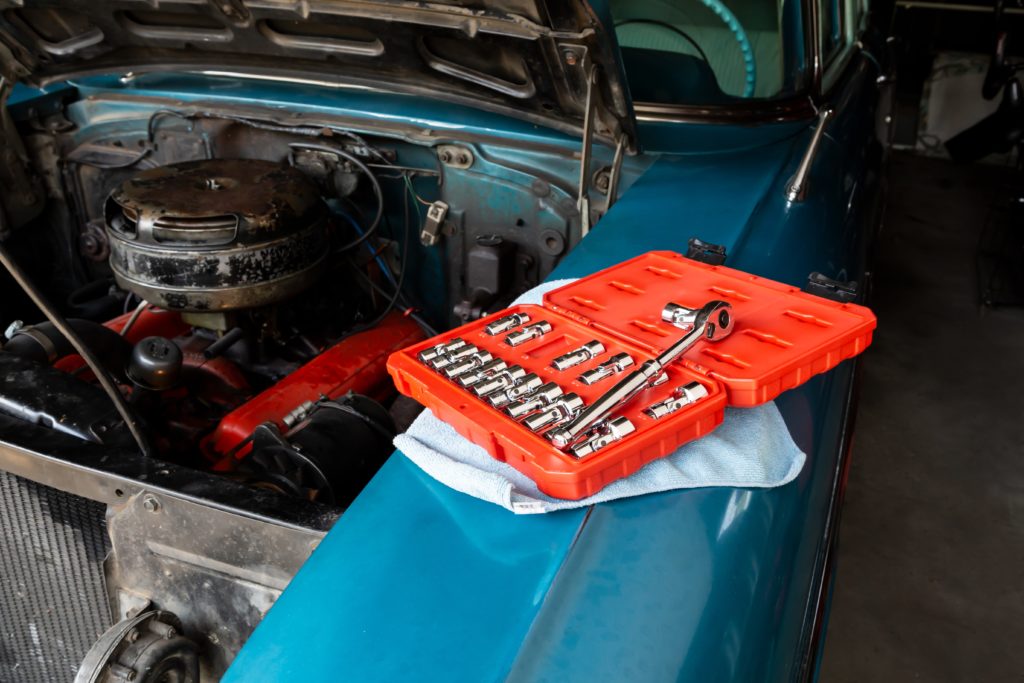 car repair tools and sockets on car hood.jpg