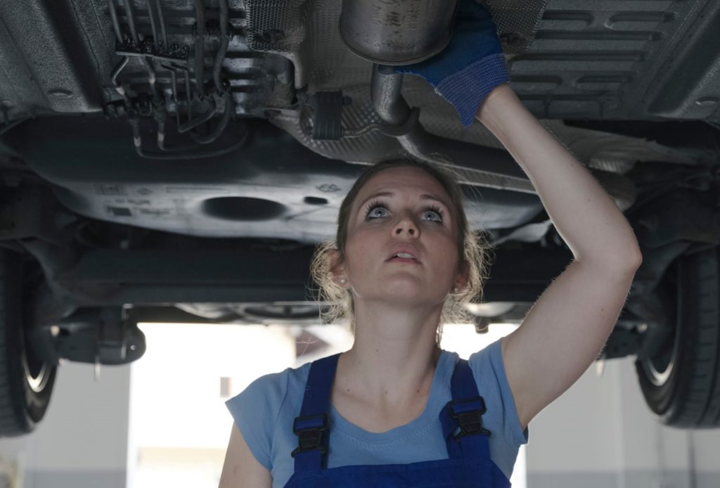 mechanic checking exhaust leak