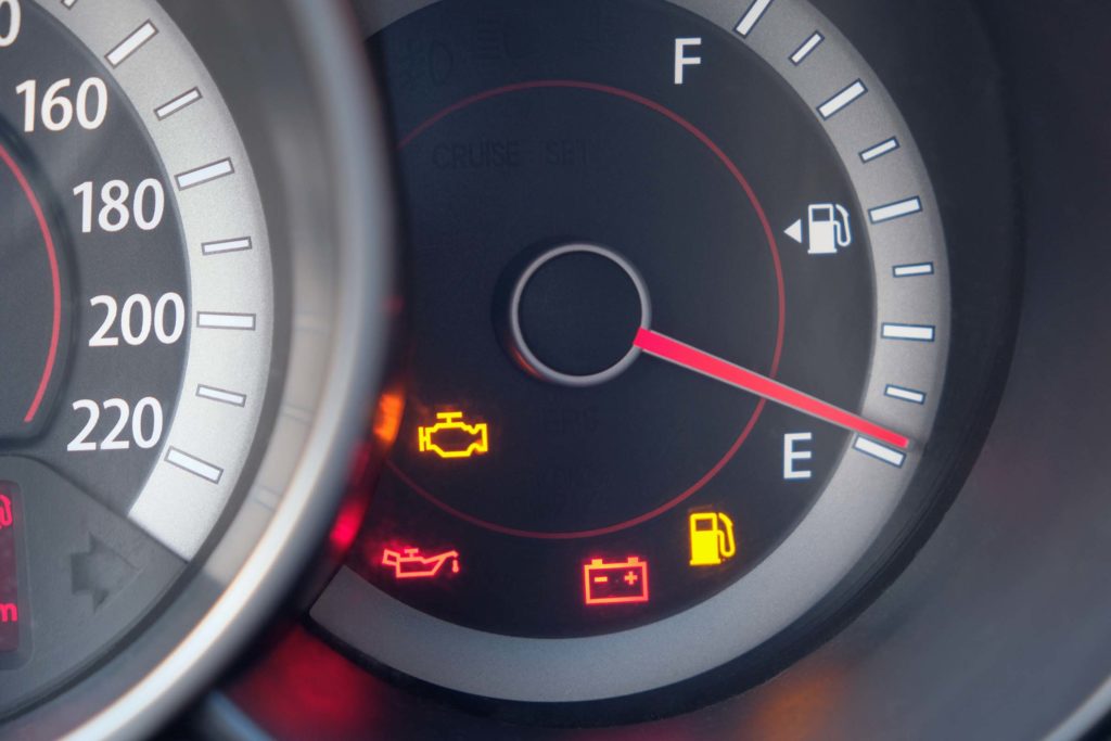 Fuel gauge of a car with warning indicating low fuel tank