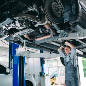 man performing inspection under the car