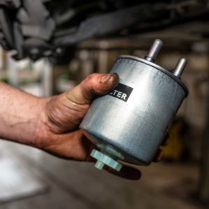 mechanic holding a car fuel filter