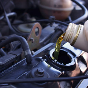 motor oil pouring into car engine