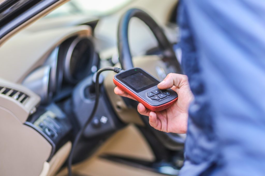 male holding a diagnostic tool use for checking automotive obd codes