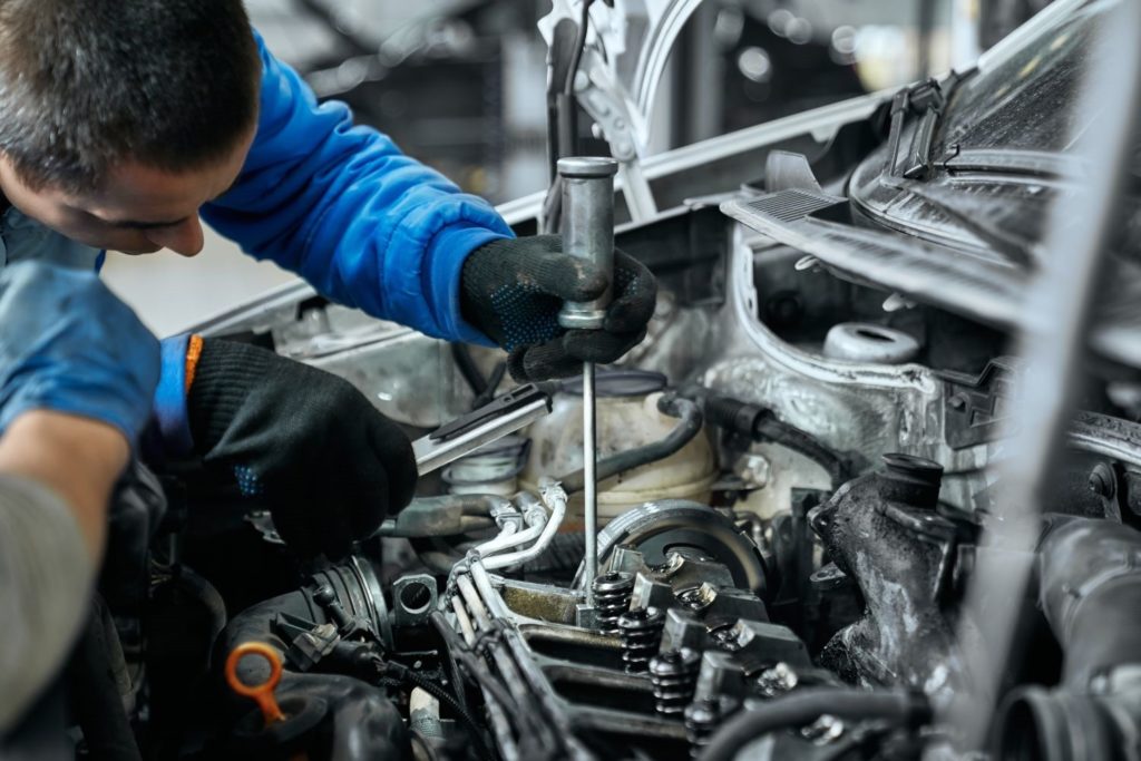 a mechanic checking car glow plugs