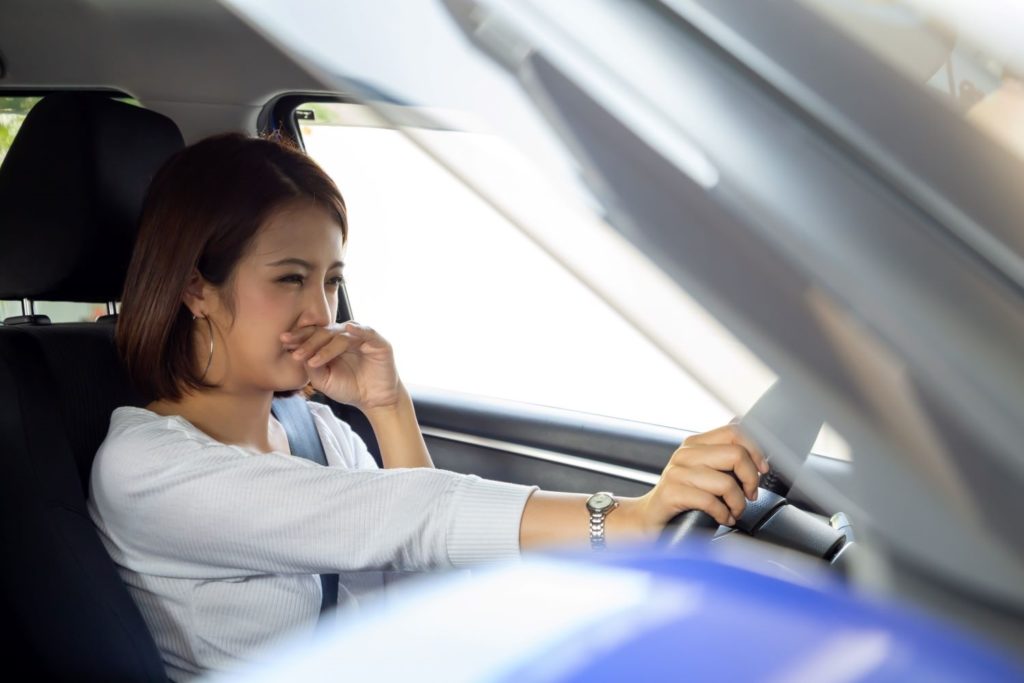 female driver covering her nose