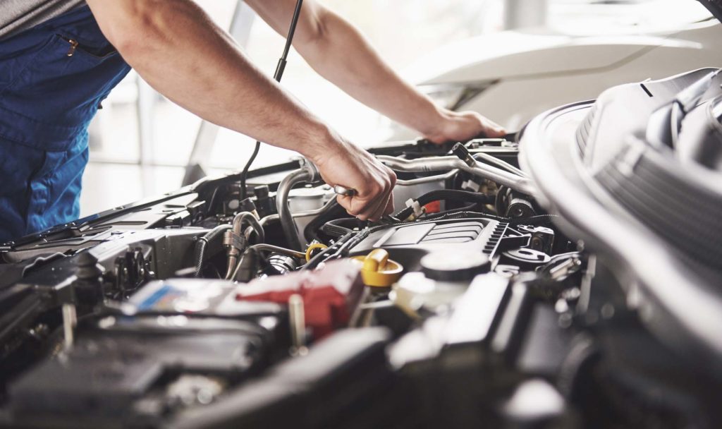 auto mechanic checking engine of modern car