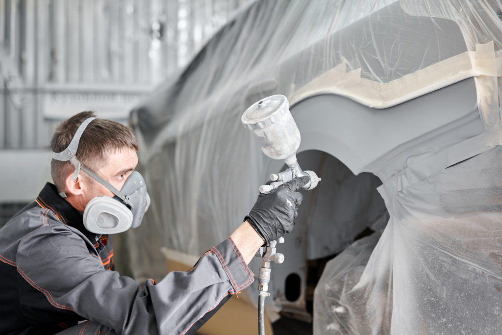 man performing repainting on car rear