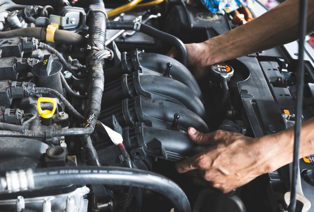 automotive intake manifold attached to a car engine