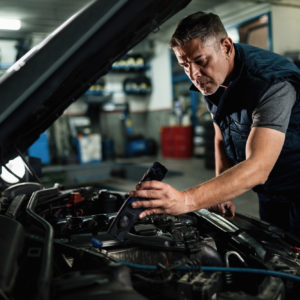 mechanic uses lamp to find transmission fluid pressure sensor