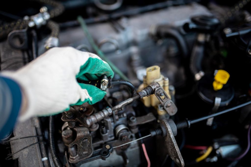 mechanic holding an old fuel injector