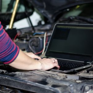 female mechanic diagnosing car