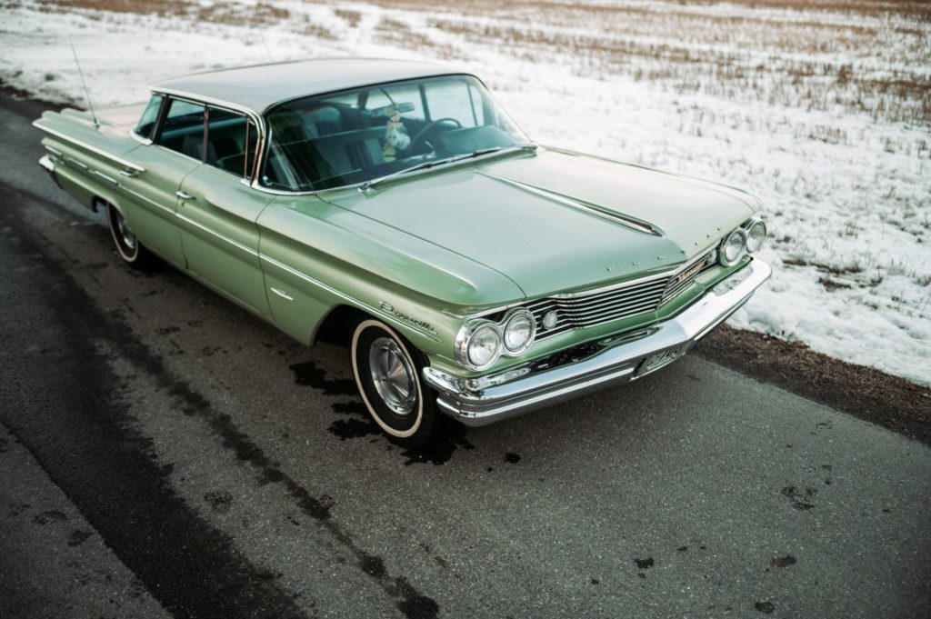 green classic car on a snowy area