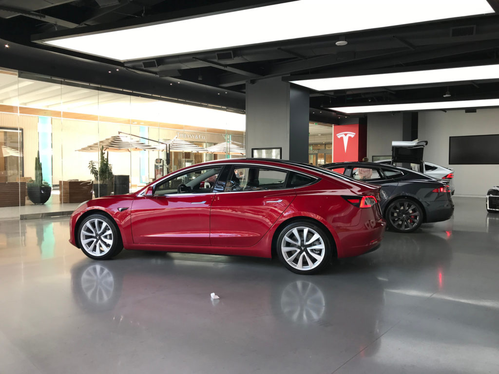 red and black tesla cars in a showroom inside the mall