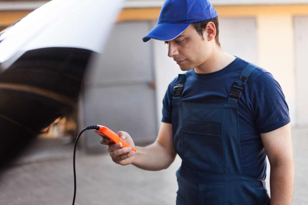 young adult holding obd diagnostic tool