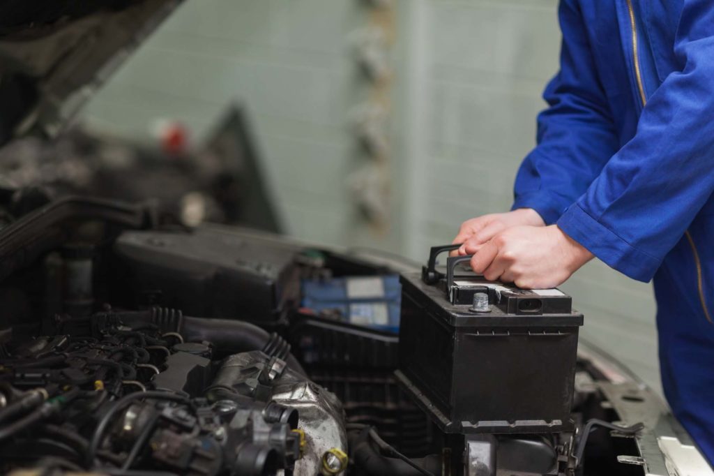 mechanic changing black car battery