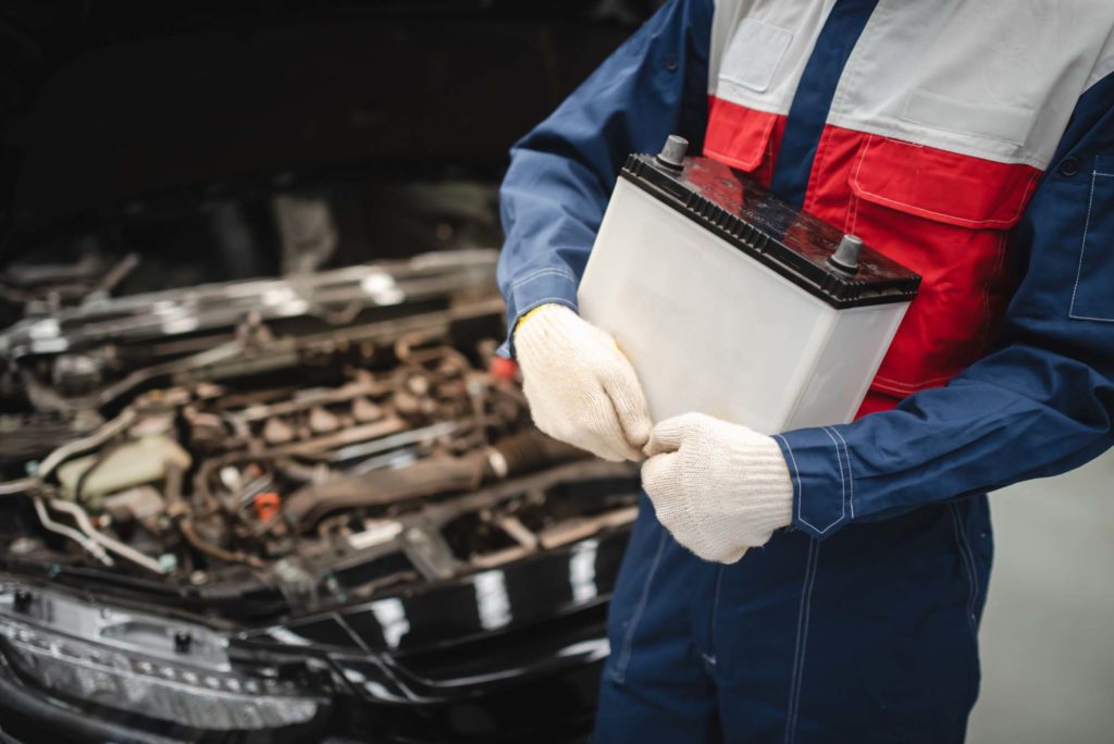 mechanic doing car battery maintenance