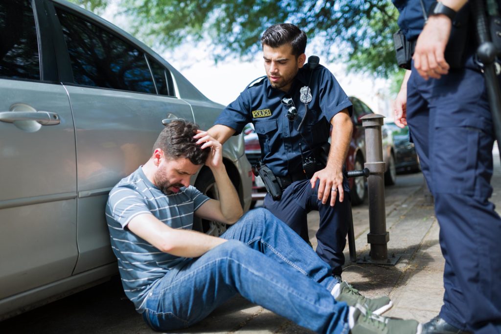 police officers talking to injured pedestrian