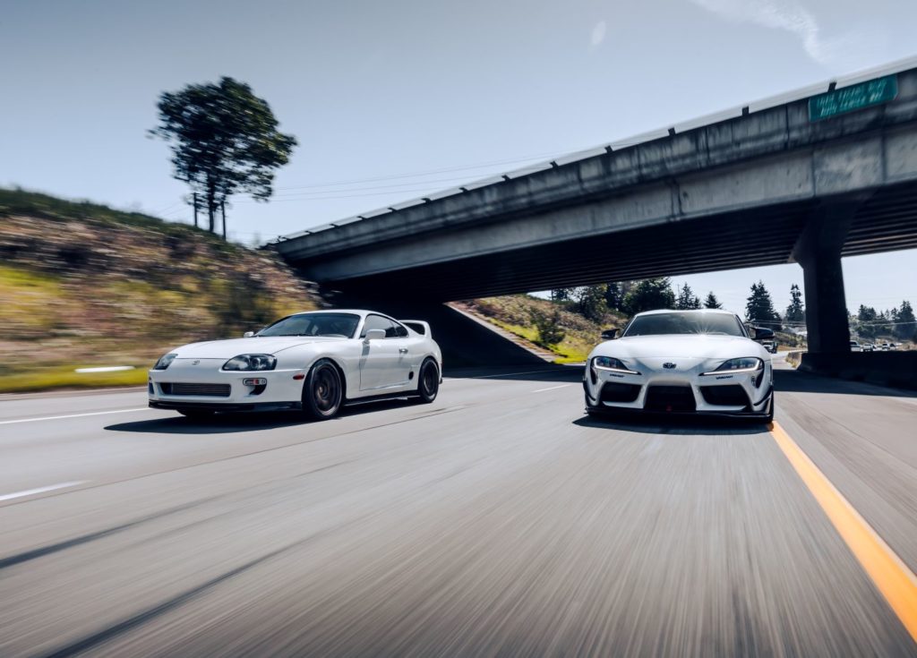 two toyota supras racing on a highway