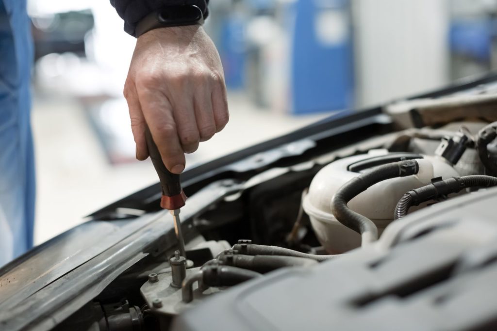 mechanic adjusting car headlight