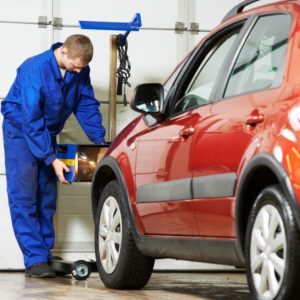 mechanic checking car headlight alignment